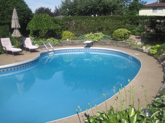 Tan rubber safety surface pool deck with lounge chairs