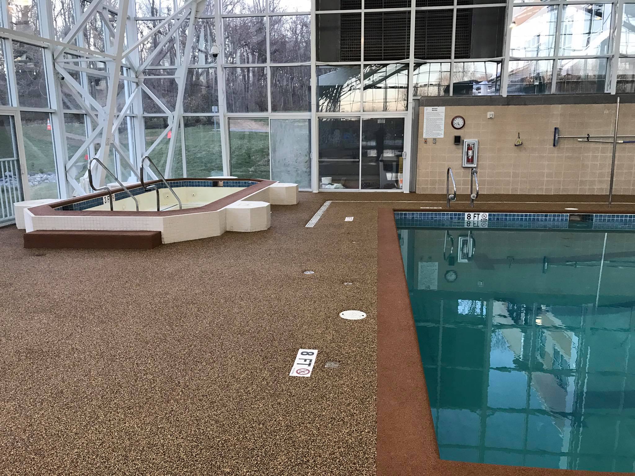 Indoor aquatic facility with rubber safety surface around pool and spa